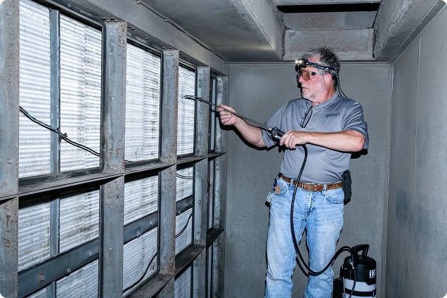 HVAC technician inspecting air conditioning unit with specialized tools for optimal performance.